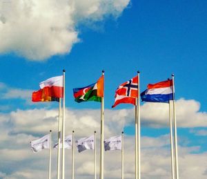 Low angle view of flag flags against blue sky