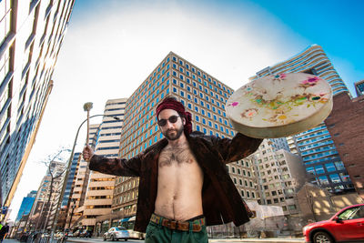 Low angle view of young man standing against built structure