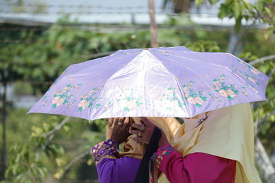 Midsection of woman holding umbrella