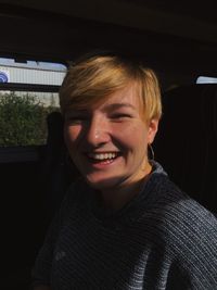 Portrait of smiling young woman in car