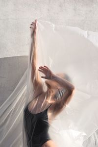 Woman with arms raised covered in plastic