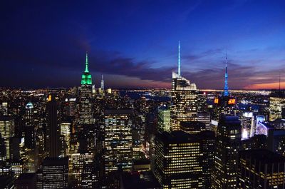 Illuminated cityscape against sky at night