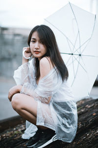 Young woman looking down while sitting outdoors