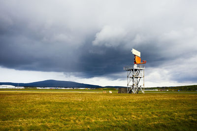 Radar installaton in a field against darkening sky