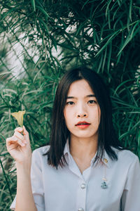 Portrait of beautiful woman holding plant