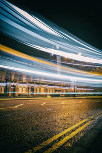 Light trails on road against sky at night