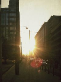 Sun shining through buildings in city