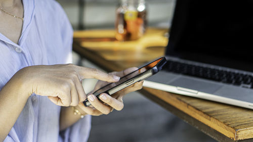 Midsection of man using mobile phone