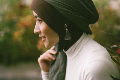 Close-up of smiling woman wearing hijab standing outdoors