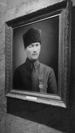 Portrait of young man standing against wall