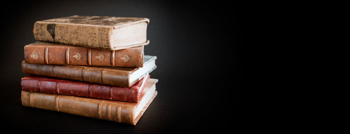 Close-up of stack on table against black background