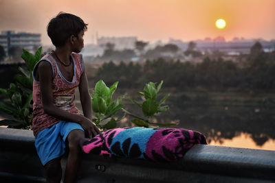 Child sitting and watching sunset