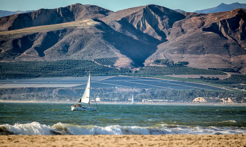 Scenic view of sea and mountains against sky