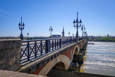 Bridge over river against sky in city