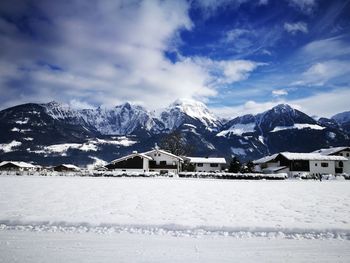 Houses on snowcapped mountains against sky