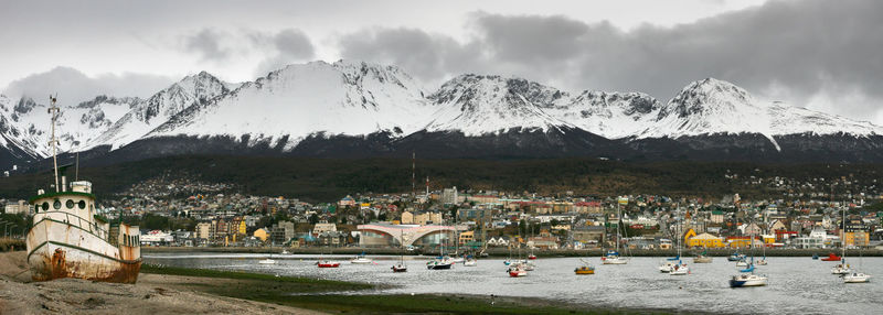 Panoramic view of townscape by mountains against sky