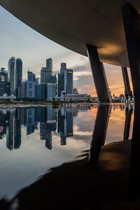 Scenic view of river and buildings against sky during sunset