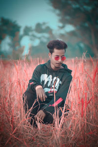 Young man sitting on field