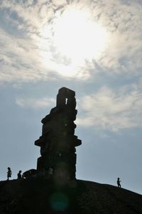 Silhouette of men on cloudy sky