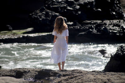 Rear view of woman standing on beach