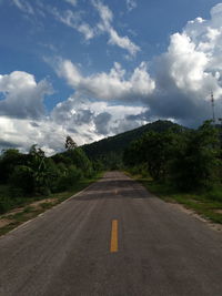 Road by trees against sky