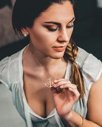 Close-up of woman holding anchor pendant