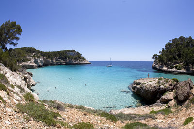 Scenic view of bay against clear blue sky