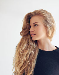 Young woman looking away against wall