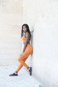 Portrait of young woman against wall