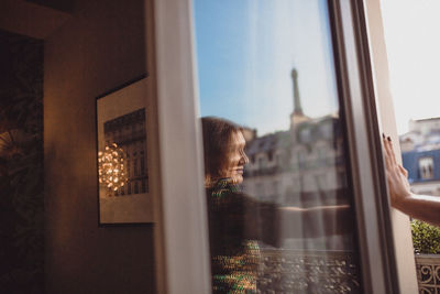 Reflection of person on glass window at home