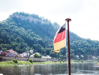 Scenic view of river by mountains against sky