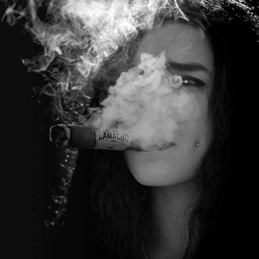 smoke - physical structure, smoking - activity, one person, bad habit, portrait, smoking issues, social issues, young adult, activity, cigarette, smoke, smoking, warning sign, communication, headshot, sign, holding, tobacco product, black background, human face, beautiful woman, hairstyle, careless