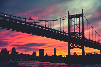 Low angle view of silhouette triborough bridge over east river during sunset