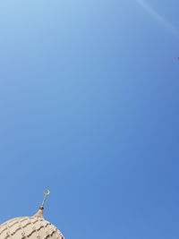 Low angle view of birds on roof against clear sky