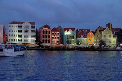 Boats in sea by city against sky