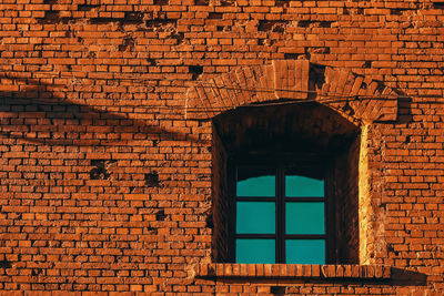 Low angle view of window on brick wall