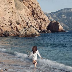 Rear view of woman standing at sea