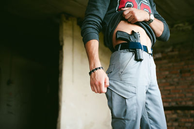 Midsection of man standing against wall