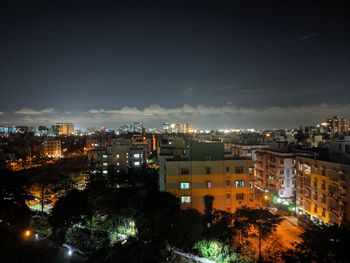 High angle view of illuminated buildings against sky at night