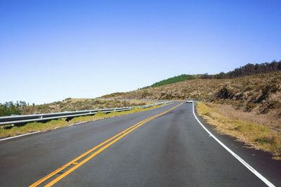 Road amidst landscape against clear blue sky