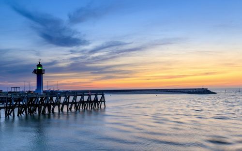Pier over sea against sky during sunset