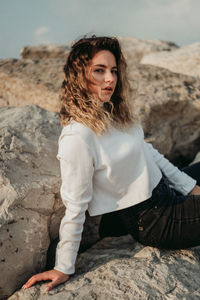 Portrait of woman sitting on rock