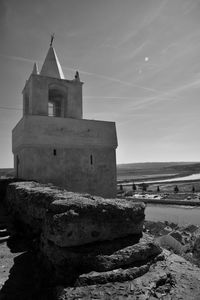 Built structure by sea against sky