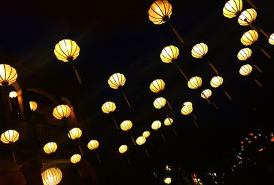 Low angle view of illuminated lanterns hanging at night