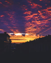 Silhouette buildings against sky during sunset