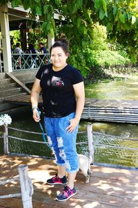 Portrait of woman standing on pier over river