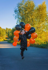 Rear view of woman with balloons on field