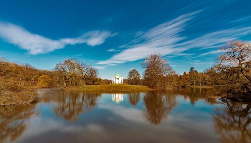 Scenic view of lake by trees against blue sky