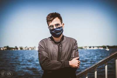 Portrait of young man standing against sky