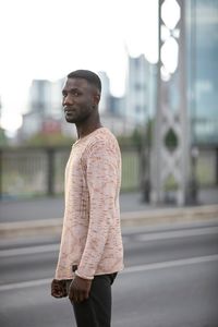 Young man looking away in city